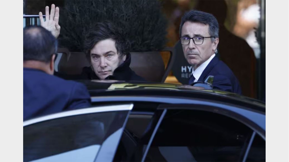 Javier Milei saluda desde un auto en Madrid antes de su viaje para el evento de Javier Milei en Córdoba.