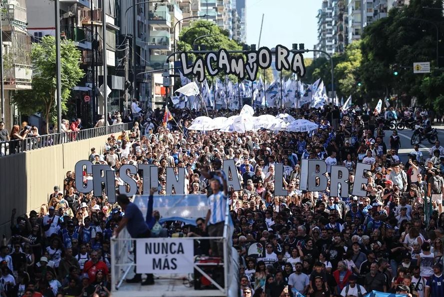 Manifestación masiva en Plaza de Mayo por los 50 años de la dictadura en Argentina, con personas sosteniendo carteles.