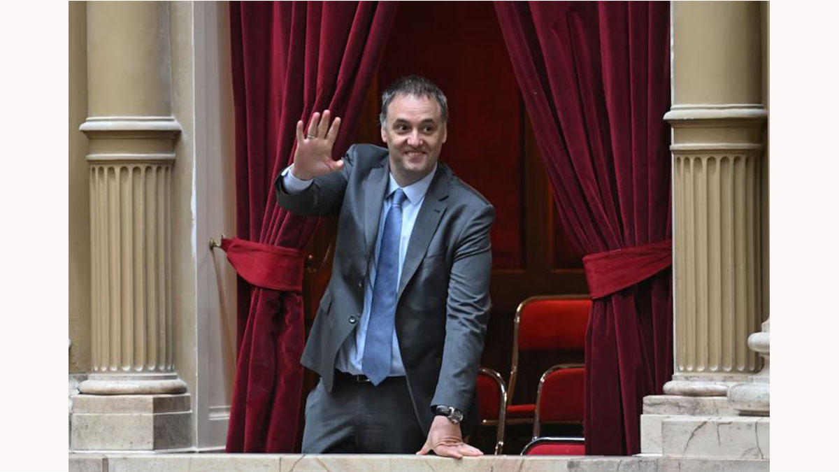 Manuel Adorni saluda desde un palco de la Cámara de Diputados antes de su informe de gestión ante la oposición
