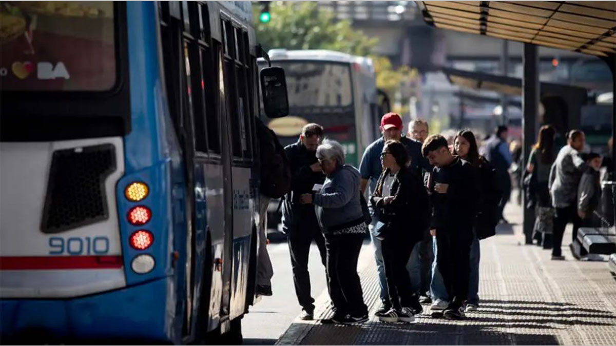 Pasajeros aguardan en una parada durante la jornada que marca el aumento de colectivos en el AMBA.