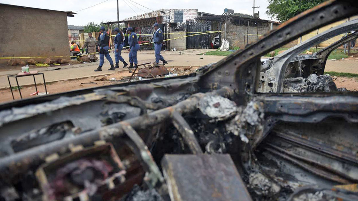 Vehículos calcinados frente a una taberna tras el tiroteo en Wedela, Sudáfrica