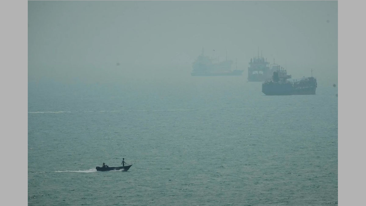 Lancha motora junto a buques mercantes anclados entre la bruma en el estrecho de Ormuz, frente a Bandar Abbas, Irán, en el contexto del ataque a un buque de carga iraní.