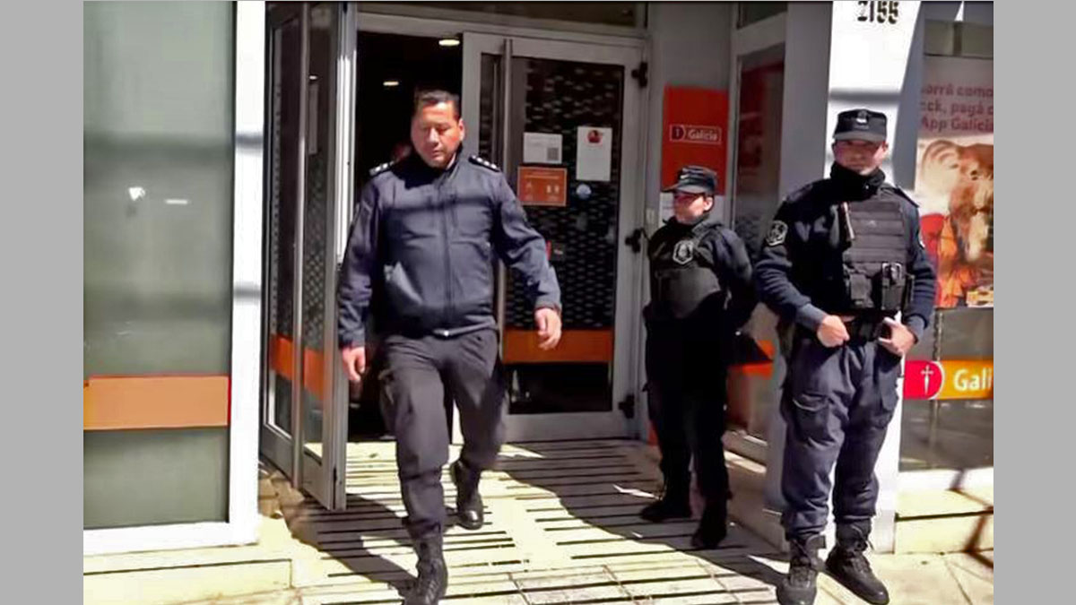 Clientes y policías frente al banco galicia de Lomas del Mirador tras el asalto al banco galici