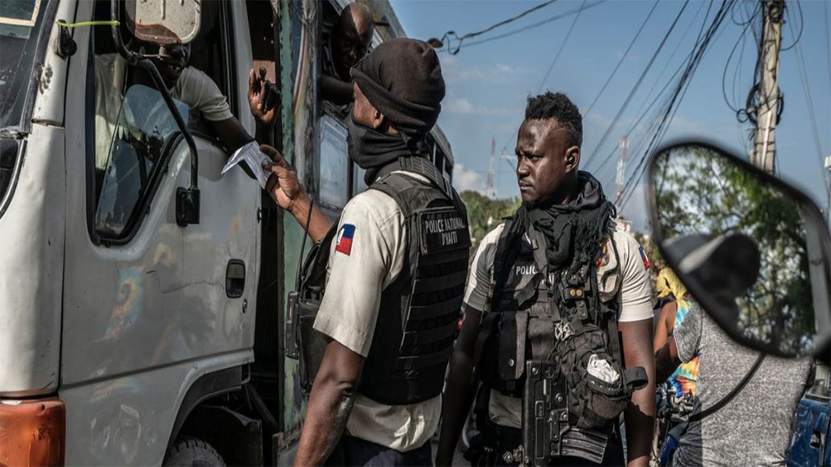 Policía haitiana controla la documentación de un conductor en un puesto de control en Haití.