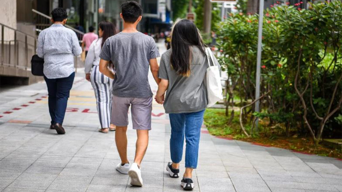 Citas para funcionarios en Singapur, una pareja camina por la ciudad